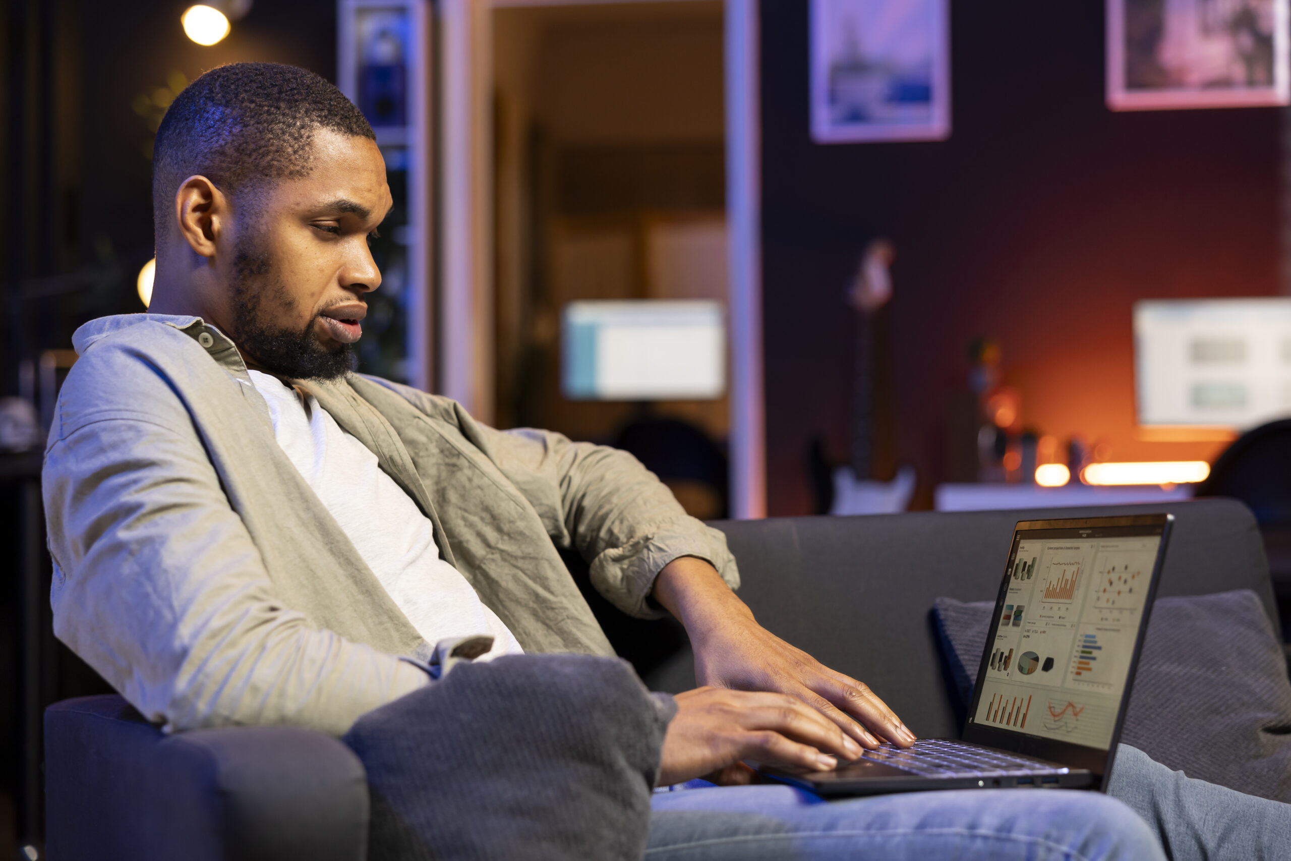 african american specialist working from home using financial graphs analysis